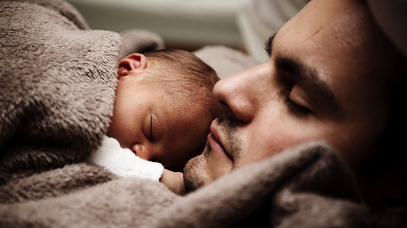Man with baby on chest